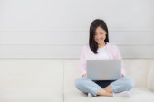 Young asian business woman work from home with laptop computer online to internet on sofa in living room, freelance girl using notebook sitting on couch with comfort and relax, lifestyles concept. t-shirt #658267054