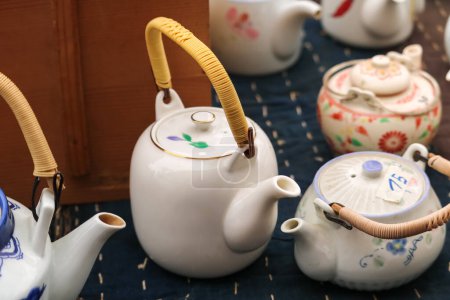 Photo for Japanese floral-style porcelain teapots with wooden handle - Royalty Free Image