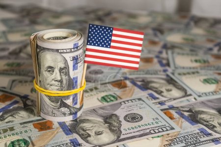 Eine Rolle US-Dollar mit amerikanischer Flagge und Banknoten. zusätzlich zu anderen Rechnungen. 