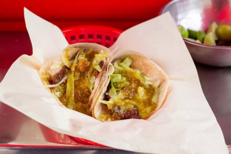 2 mexican tacos with green sauce in food truck