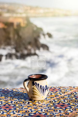 traditional Mexican cup made of clay facing the sea, Mexican coffee cup