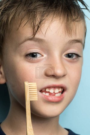 Foto de Niño pequeño sosteniendo un cepillo de dientes de bambú cerca de su cara. Aspecto europeo. retrato de primer plano - Imagen libre de derechos