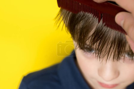 Foto de Le están peinando el pelo a un niño. preparación para el corte de pelo - Imagen libre de derechos