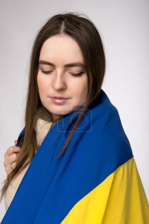 Foto de Una chica de apariencia europea con una bandera ucraniana de cerca - Imagen libre de derechos