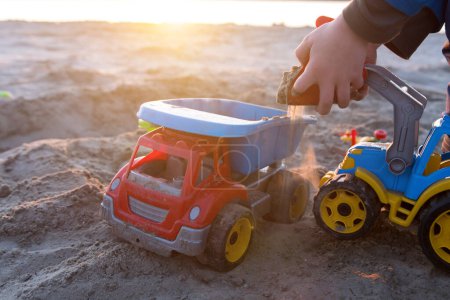 Foto de Niño jugando con coches de juguete en la playa. enfoque suave - Imagen libre de derechos