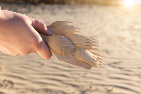 Foto de Cucharas de madera en la mano sobre fondo de arena - Imagen libre de derechos