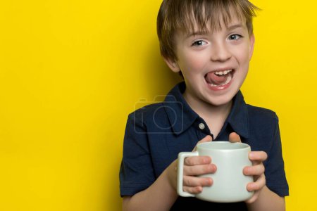 Foto de Un niño de apariencia europea sostiene una copa en sus manos. mirada alegre - Imagen libre de derechos
