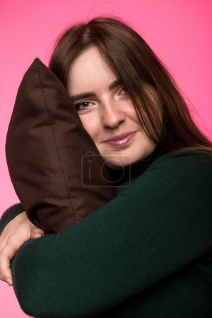 Téléchargez les photos : Une femme d'apparence slave étreint un oreiller. portrait avec un sourire gros plan - en image libre de droit