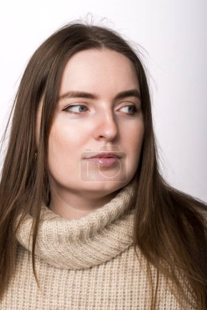 Foto de Un retrato de cerca sobre un fondo blanco de una mujer de apariencia eslava. pelo castaño, mirada lateral - Imagen libre de derechos