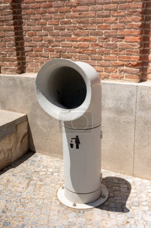 Eye-catching trash can in the shape of a pipe stands out against a modern urban backdro