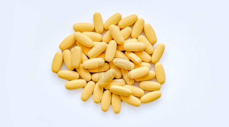 Close-up texture of yellow multivitamin tablets on white background. Healthy lifestyle concept.