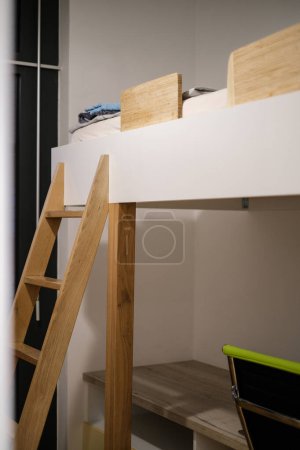 Klassisches weißes Etagenbett mit Holzlattenleiter, ideal für Geschwister oder kleine Räume.