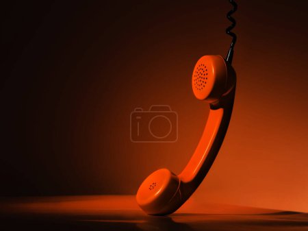 Photo for Orange telephone receiver on the table - Royalty Free Image