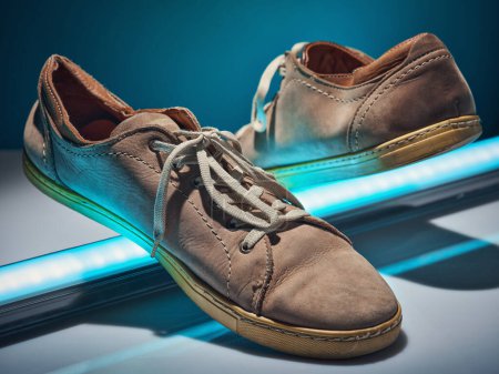 Photo for Glowing lightstick elevates brown sneakers. - Royalty Free Image