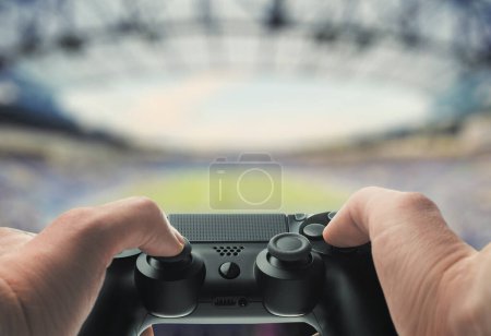 Hands Holding Game Controller with Stadium Background