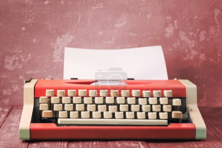 Máquina de escribir vintage roja en escritorio de madera