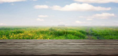 Foto de Mesa de madera con vistas al soleado campo de flores silvestres - Imagen libre de derechos