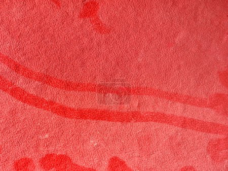 Red textured surface with dust close-up 