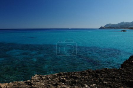 El hermoso agua turquesa en la bahía de Cala Rajada Mallorca en un maravilloso soleado día de primavera con un cielo azul claro