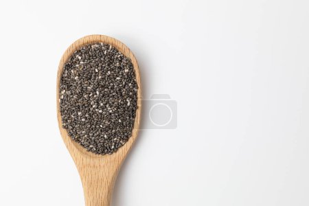 Foto de Semilla de chía ecológica en una cuchara de madera aislada sobre un fondo blanco. - Imagen libre de derechos