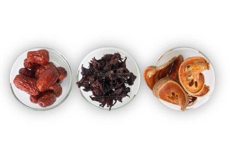 Téléchargez les photos : Vue de dessus de trois types de fruits secs asiatiques, bael, okra et jujube dans des bols en verre sur fond blanc. - en image libre de droit