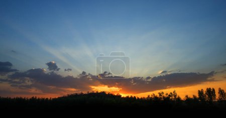 Téléchargez les photos : Pendant les heures de crépuscule et de coucher du soleil, les rayons lumineux brillent à travers le ciel et les nuages, c'est la vraie beauté de la nature.. - en image libre de droit
