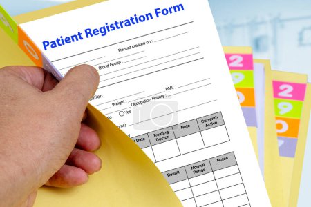 Téléchargez les photos : Dossier médical jaune ouvert à la main puis révélant le formulaire d'inscription du patient. - en image libre de droit