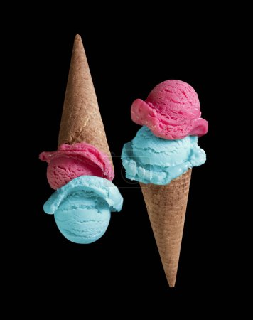 Téléchargez les photos : Glace bleue et rose dans un cône de gaufre aux myrtilles et cerises sur fond gris - en image libre de droit