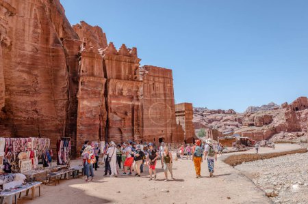 Foto de Petra, Jordania - 16 de abril de 2023: Vista de la Calle de las Fachadas, la fila de monumentales tumbas nabateas talladas en la cara del acantilado sur que se encuentra más allá del Tesoro y adyacente al Siq exterior. - Imagen libre de derechos
