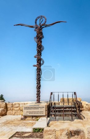 Foto de La Cruz Serpentina (también conocida como el Monumento a la Serpiente de Bronce), que simboliza la serpiente de bronce llevada por Moisés al desierto y la cruz sobre la que Jesús fue crucificado. En la cima del monte. Nebo, Jordania. - Imagen libre de derechos