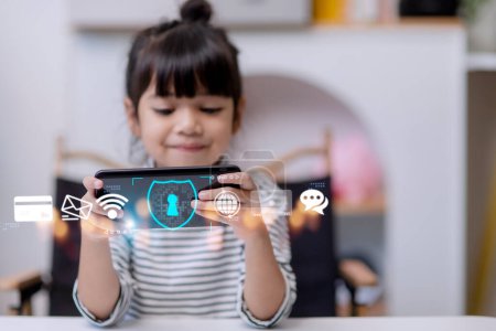 Kindersicherheit im Internet. Kleines Mädchen mit Smartphone zu Hause. Ikone der Internet-Sperren-App im Vordergrund