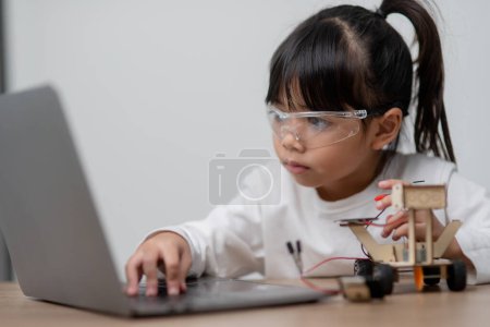 Photo for Asia students learn at home in coding robot cars and electronic board cables in STEM, STEAM, mathematics engineering science technology computer code in robotics for kids concept. - Royalty Free Image