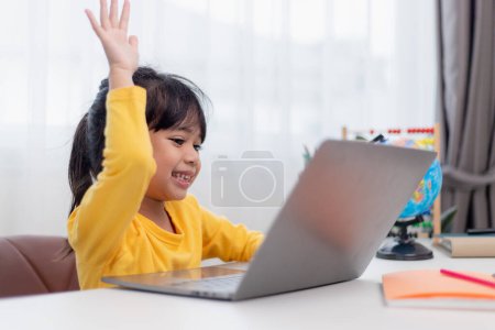 Foto de Primer día en la escuela. Niña asiática usando un ordenador portátil, estudiando a través del sistema de e-learning en línea. - Imagen libre de derechos