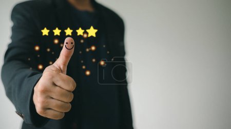 Foto de Customer satisfaction concept. Hand with thumb up Positive emotion smiley face icon and five star with copy space. - Imagen libre de derechos