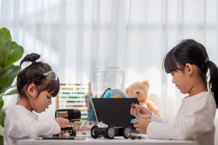 Foto de Los estudiantes de Asia aprenden en casa en la codificación de automóviles robóticos y cables de placas electrónicas en STEM, STEAM, matemática ingeniería tecnología código informático en robótica para niños concepto. - Imagen libre de derechos
