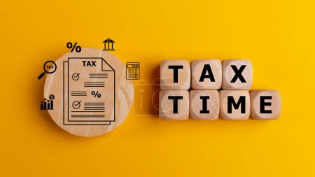 Steuerzeitkonzept mit Text auf Holzwürfeln auf gelbem Hintergrund. Steuernachzahlung oder Jahresbesteuerungskonzept.