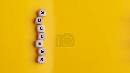 Würfel mit dem Wort Erfolg auf gelbem Hintergrund, Erfolgs-Geschäftskonzept.