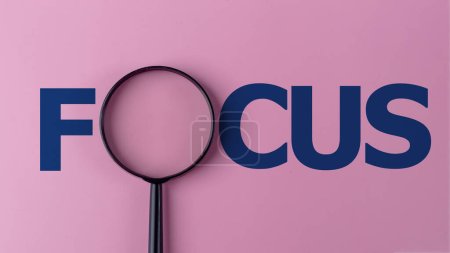 Photo for The word focus with a magnifying glass. Focusing on a target in business or education concept. - Royalty Free Image