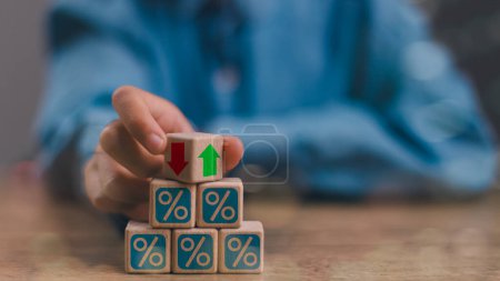 Businessmen flip wooden cubes with percentage icons and up and down arrow icons. Concept of financial interest rates and mortgage rates. Interest Rates Stocks Finance Ratings Mortgage Rates.