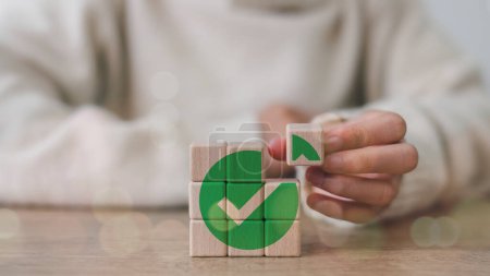 Wooden cube with a green checkmark icon. Corporate regulatory and compliance. Goals achievement and business success. Task completion. Ethical corporate. Do the right thing. Quality and ISO symbol. 