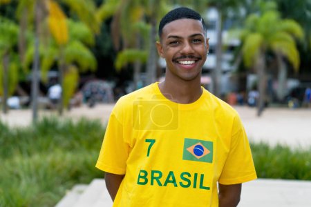 Foto de Riéndose joven de Brasil con camiseta de fútbol amarillo al aire libre en Porto Alegre - Imagen libre de derechos