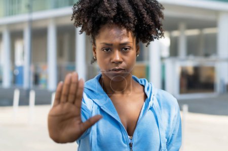 Black woman gesturing stop agains racism outdoor in the city