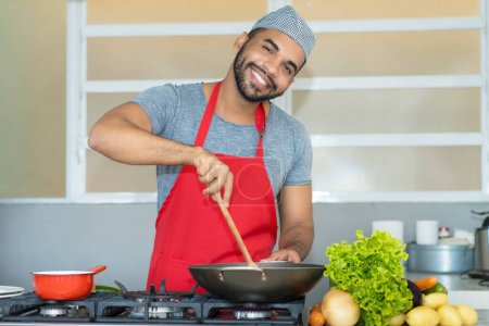 Hispanic kitchen assistant making meal at restaurant