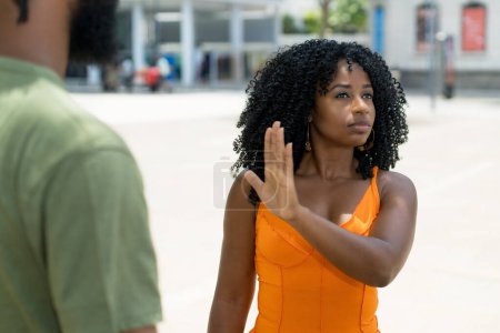 Téléchargez les photos : Femme brésilienne geste arrêt à copain dans la discussion en plein air en été en ville - en image libre de droit