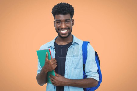 Téléchargez les photos : Rire noir mâle étudiant avec barbe et la paperasserie pour découper - en image libre de droit