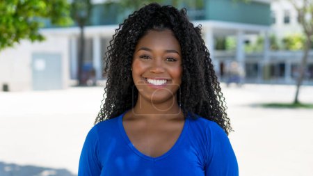 Téléchargez les photos : Portrait de femme afro-américaine riante en ville par une journée ensoleillée en été - en image libre de droit
