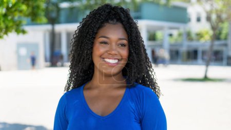 Téléchargez les photos : Portrait de femme afro-américaine heureuse en ville par une journée ensoleillée en été - en image libre de droit
