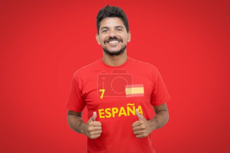 Happy spanish football fan with beard and red jersey ready for the next game