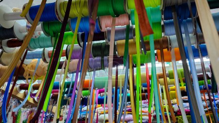 Foto de Cintas coloridas, correas, trenzas, cintas de sesgo, cordones para coser o bordar en escaparate de la tienda - Imagen libre de derechos