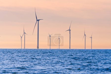 Téléchargez les photos : Parc éolien offshore. moulins à vent isolés en mer par une belle journée lumineuse Pays-Bas. énergie verte Flevoland réchauffement climatique énergies renouvelables avec des éoliennes - en image libre de droit